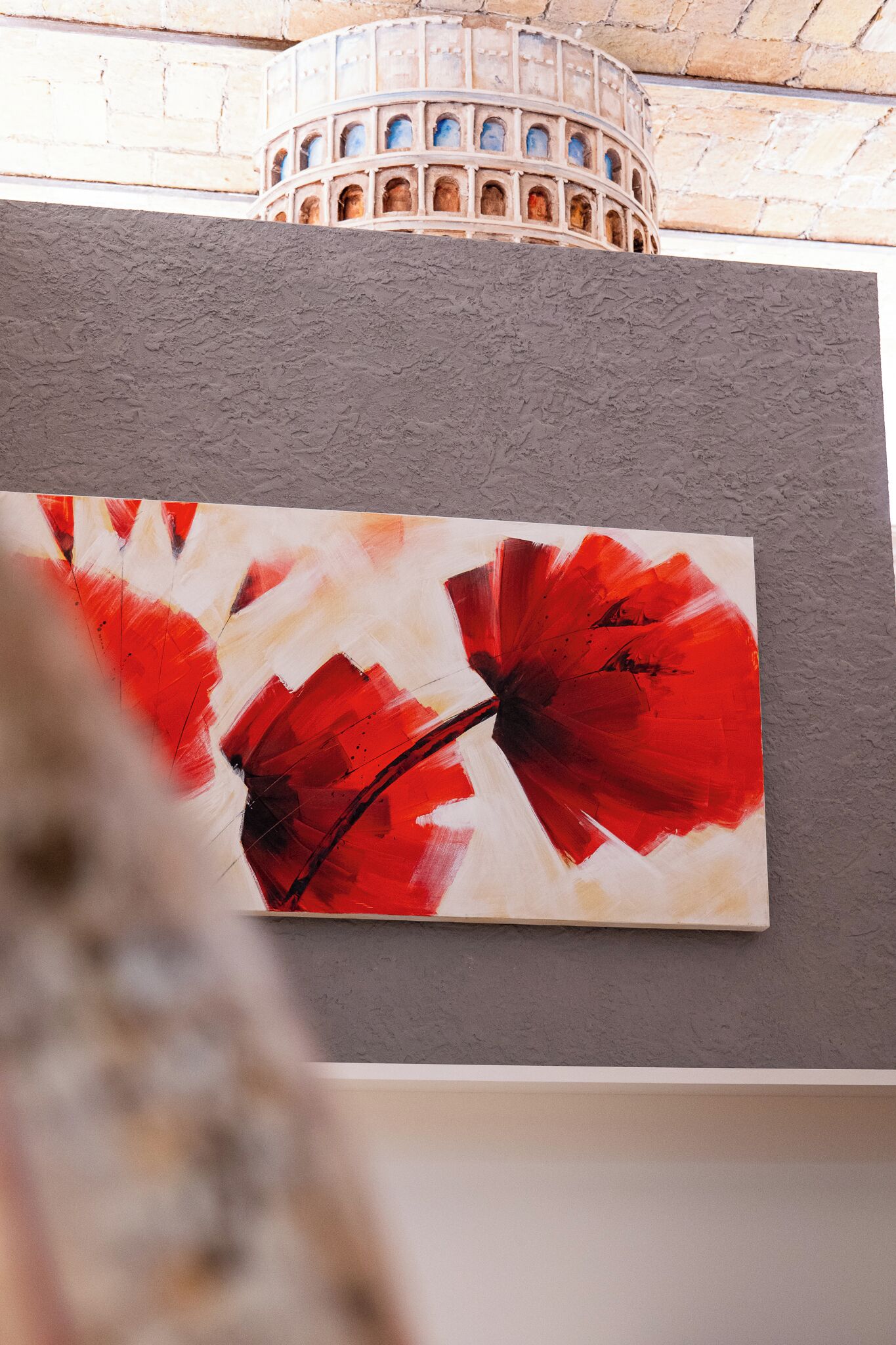 A painting of red flowers on a wall.