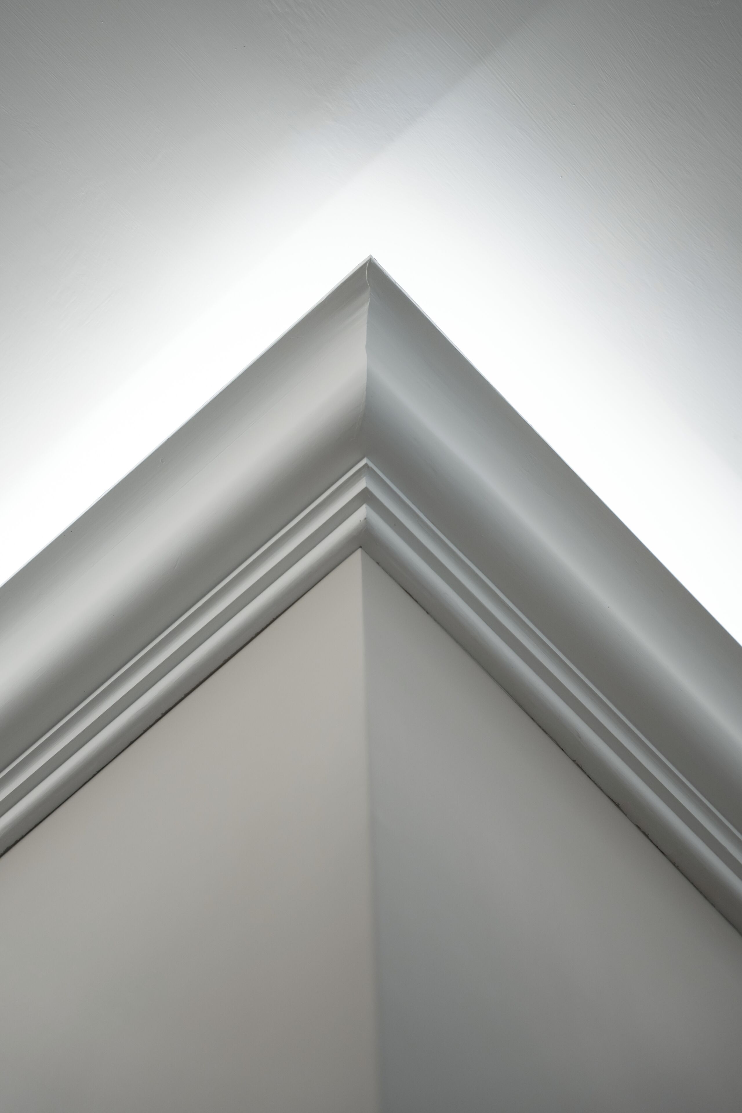 A corner of a room with a white wall and a white trim.