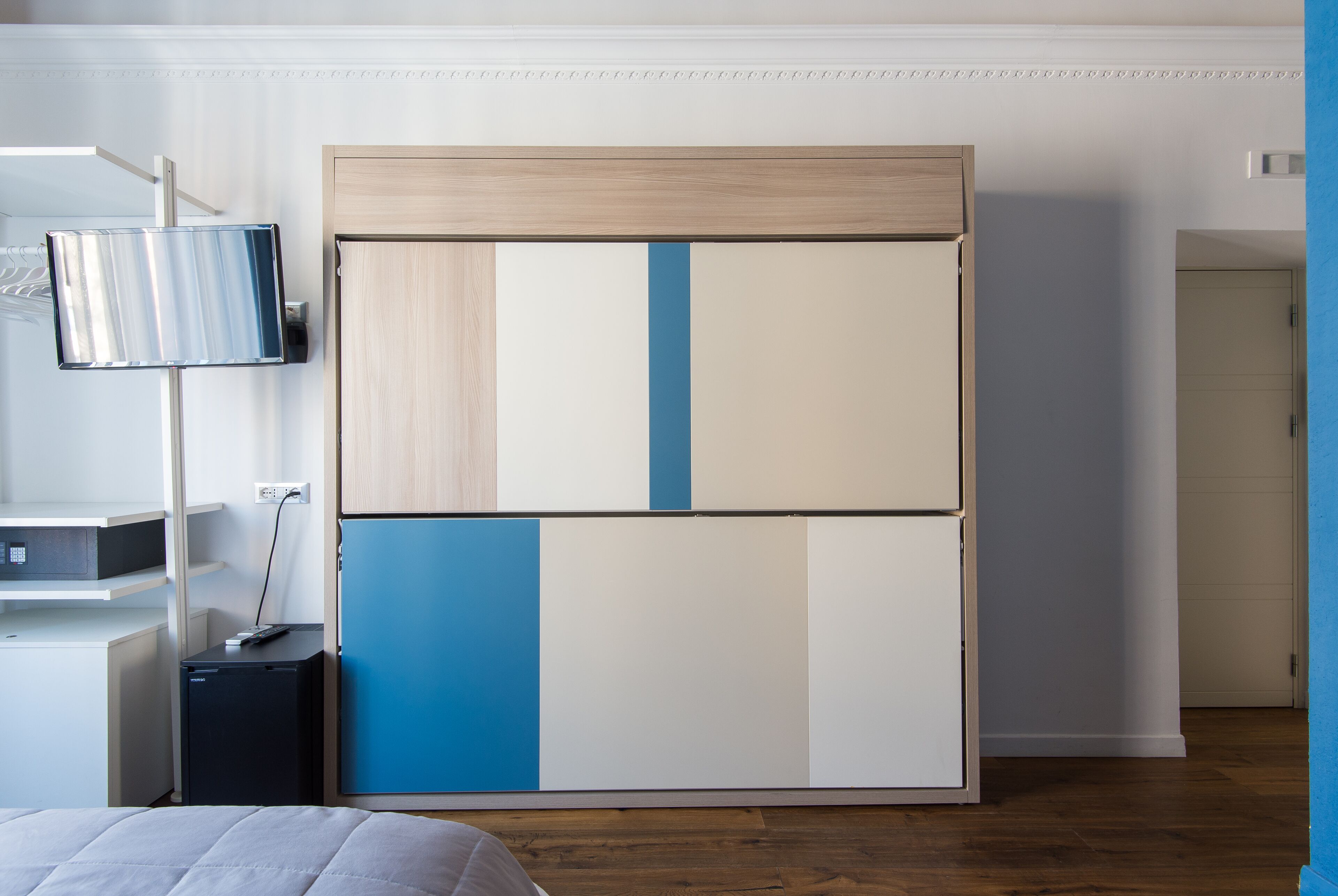 Une chambre à coucher avec un lit, une armoire, un bureau et une lampe.