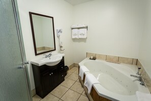 A bathroom with a sink, mirror, and bathtub. - Georges Mountain Village (Steady Brook)