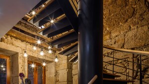 Un intérieur moderne avec un escalier, des bancs en bois et un mur en pierre.