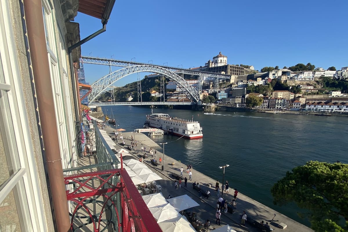 Un balcon avec vue sur une rivière, un pont et le paysage urbain.