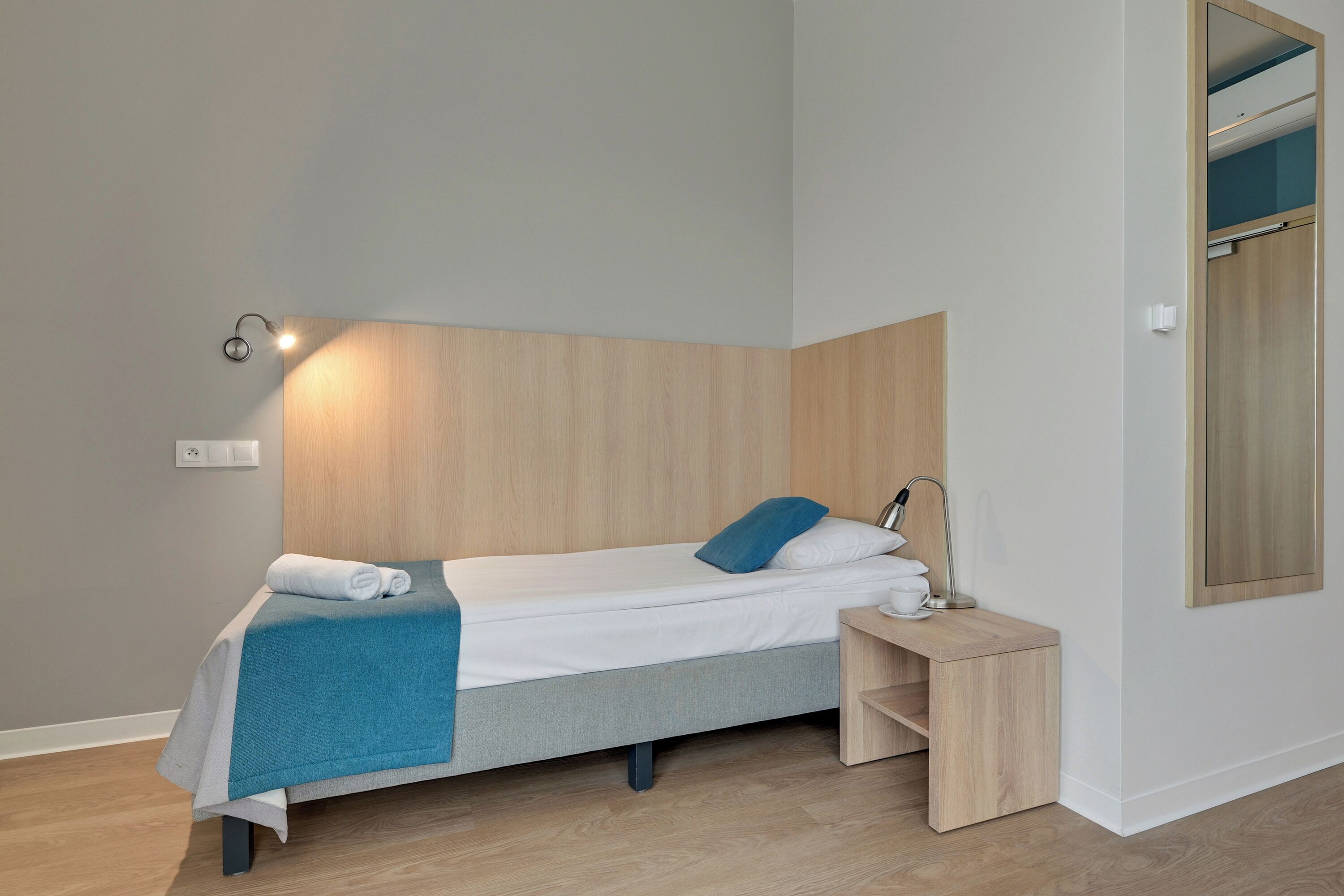Ein modernes Schlafzimmer mit Bett, Nachttisch und Spiegel.