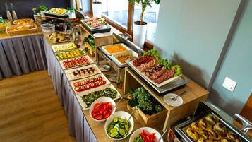 Un buffet proposant une variété de plats, notamment des viandes, des salades et des légumes.