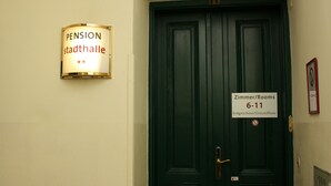 Une porte vert foncé avec une pancarte indiquant les numéros de chambre 6 à 11 et l’inscription « Zimmer/Rooms ».