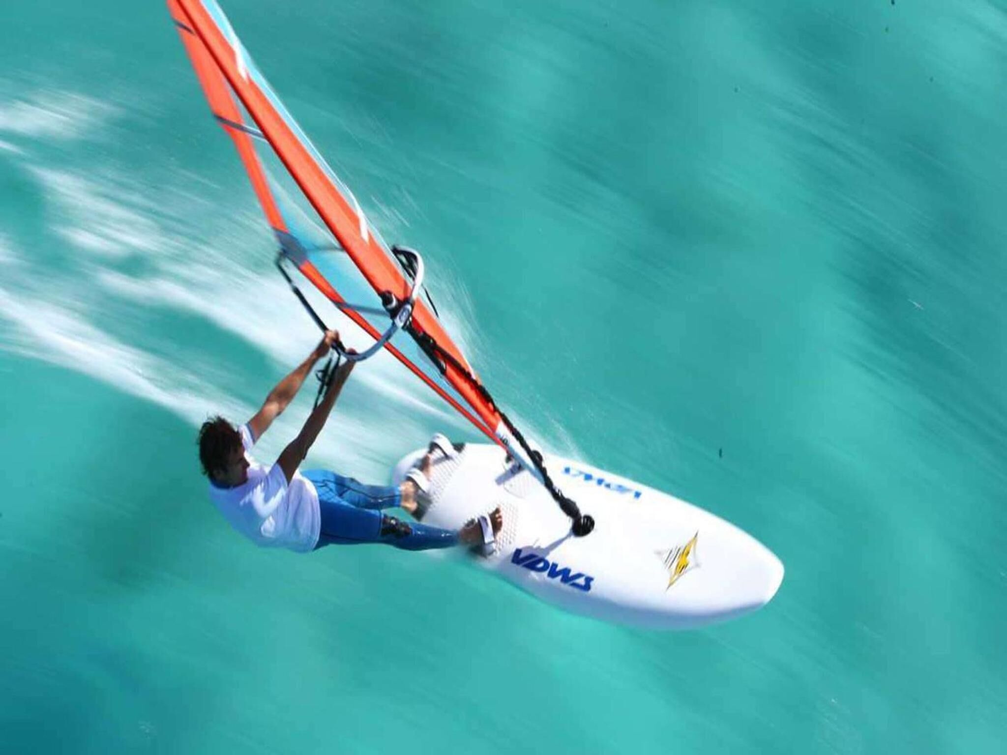 A person windsurfing with a board that has "VOWS" written on it.