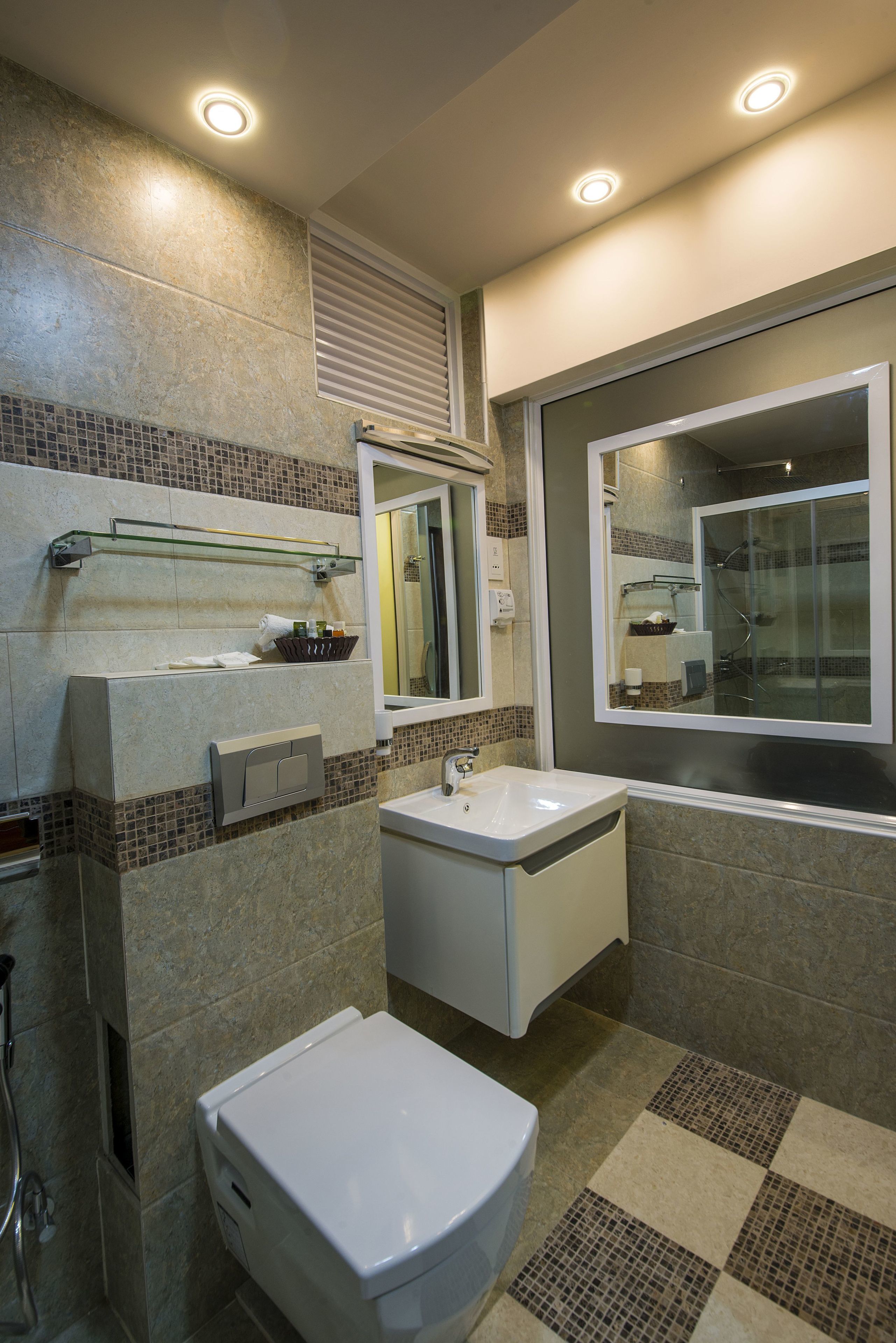 A modern bathroom with a toilet, sink, and shower.