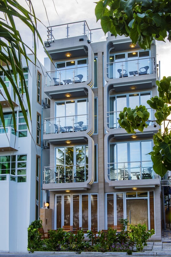 Een meerlaags gebouw met balkons, grote ramen en buitenplaatsen om te zitten.