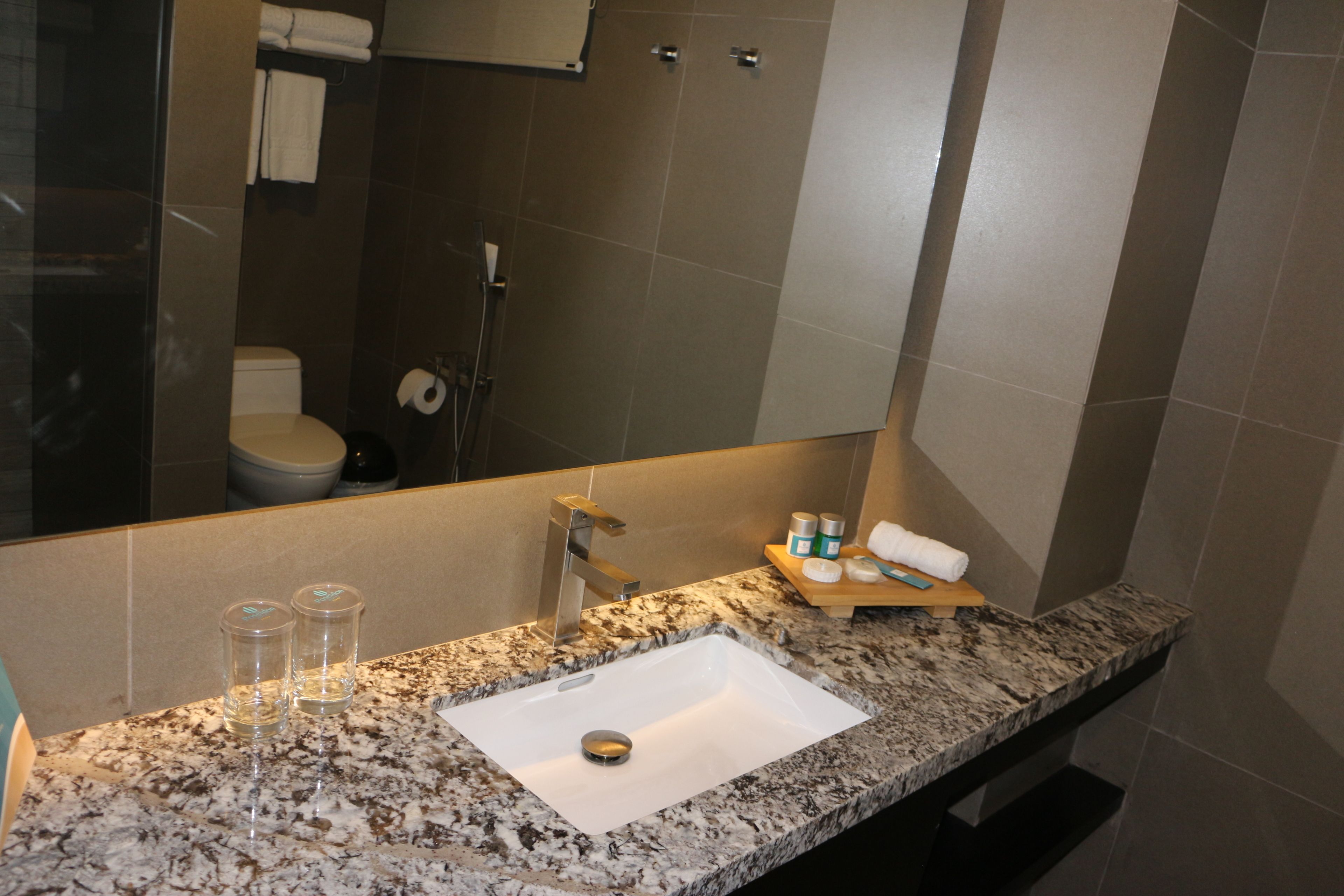 Un baño con lavabo, espejo y artículos de aseo.