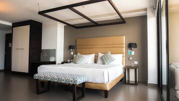 A modern hotel room with a large bed, bedside tables, a wardrobe, and a television.