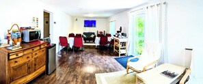 A compact living space with a dining area, a kitchen with a microwave and toaster, and a television. - Cedar Drive Inn (North Stormont)