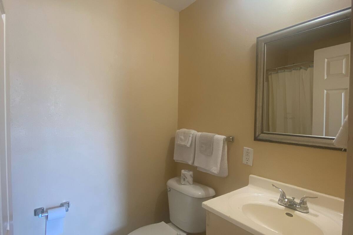 A small bathroom with a toilet, sink, and mirror.