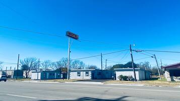 A motel with a 'Motel' sign, a speed limit sign of 40, and a 'Sunrise Motel' sign.