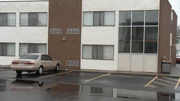 Un immeuble de deux étages avec un parking situé devant.