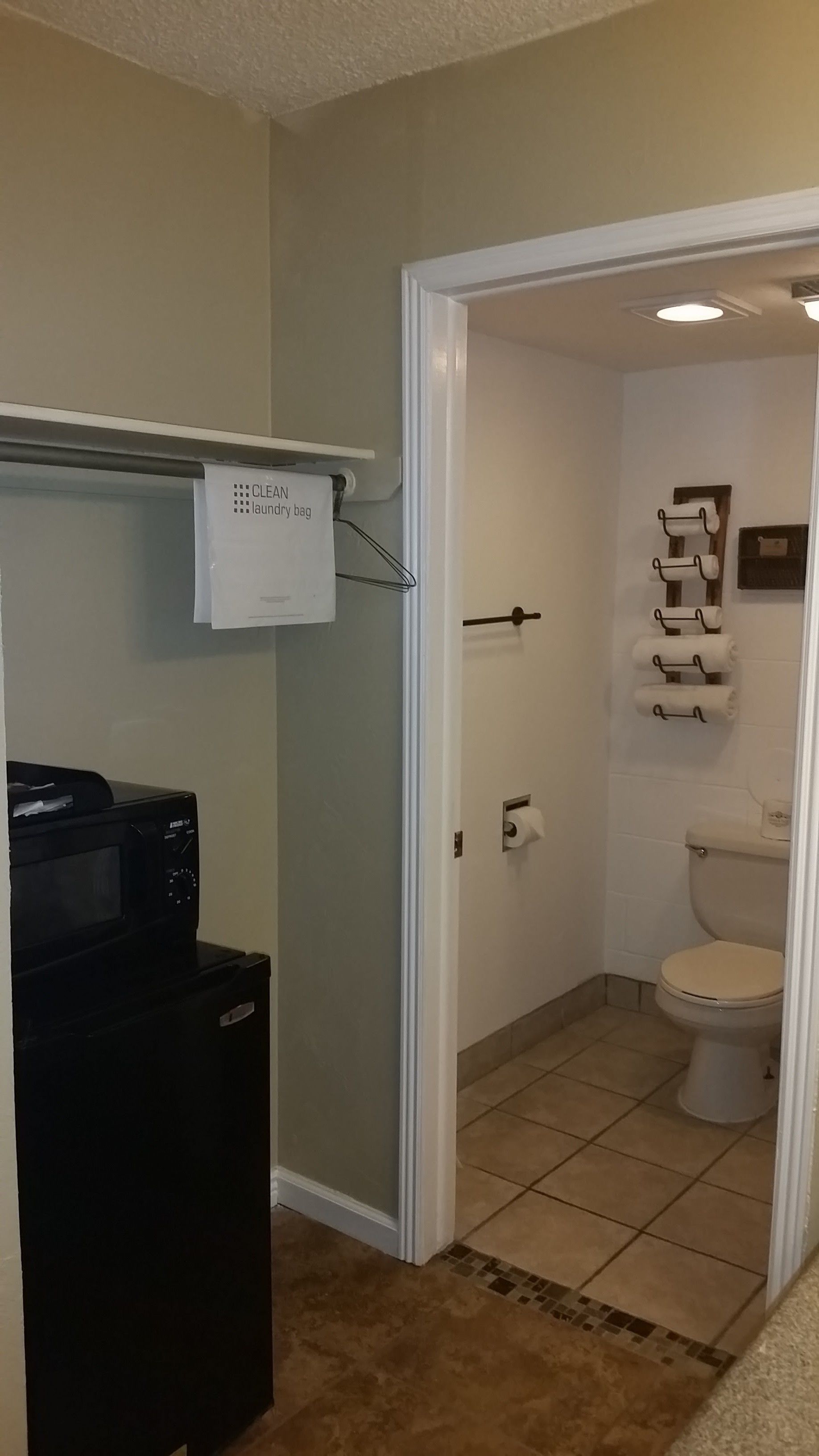 A laundry room with a washing machine, a dryer, and a sign indicating a clean laundry bag.