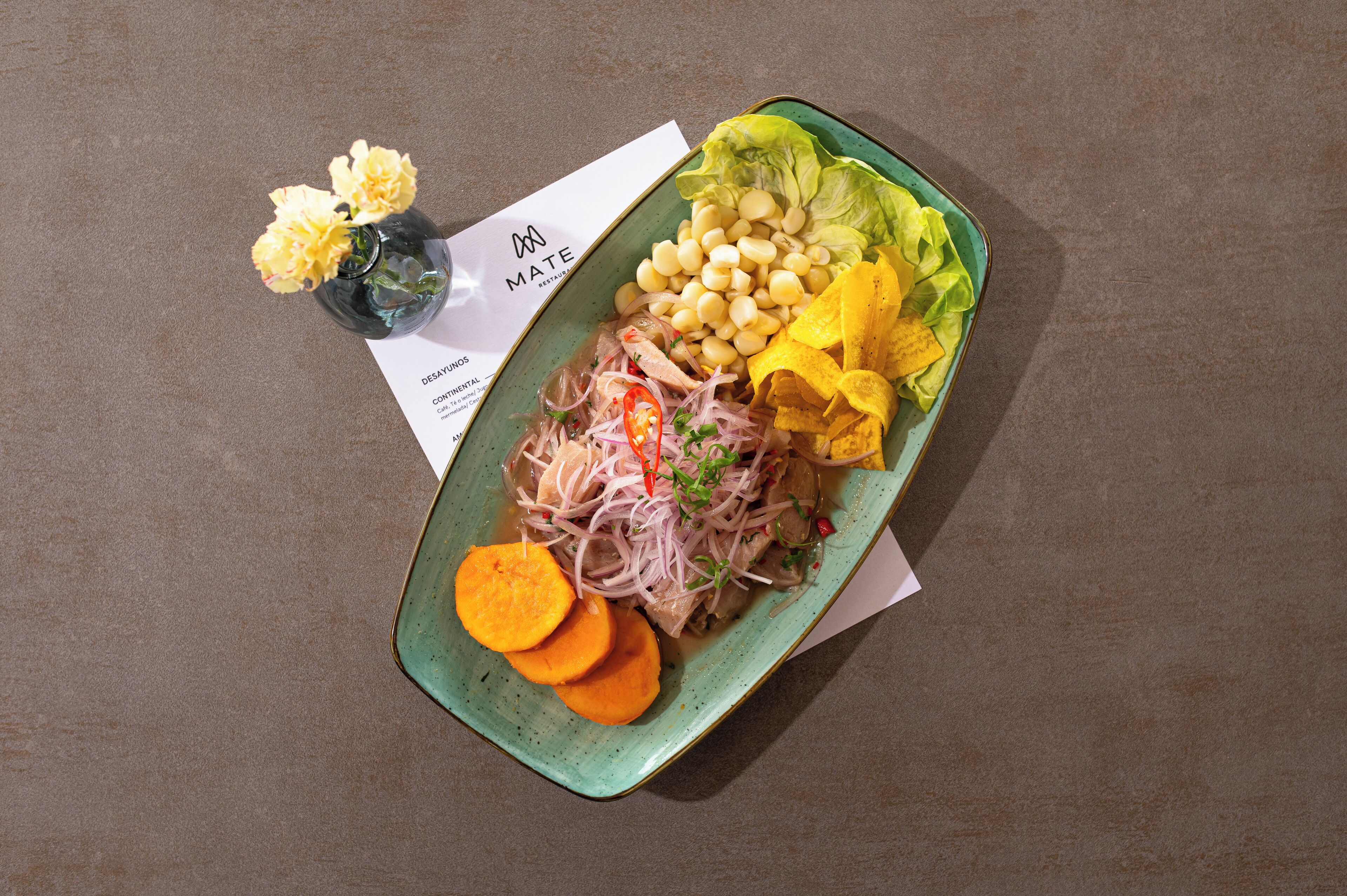 A plate of food with various ingredients including beans, lettuce, and sliced vegetables.