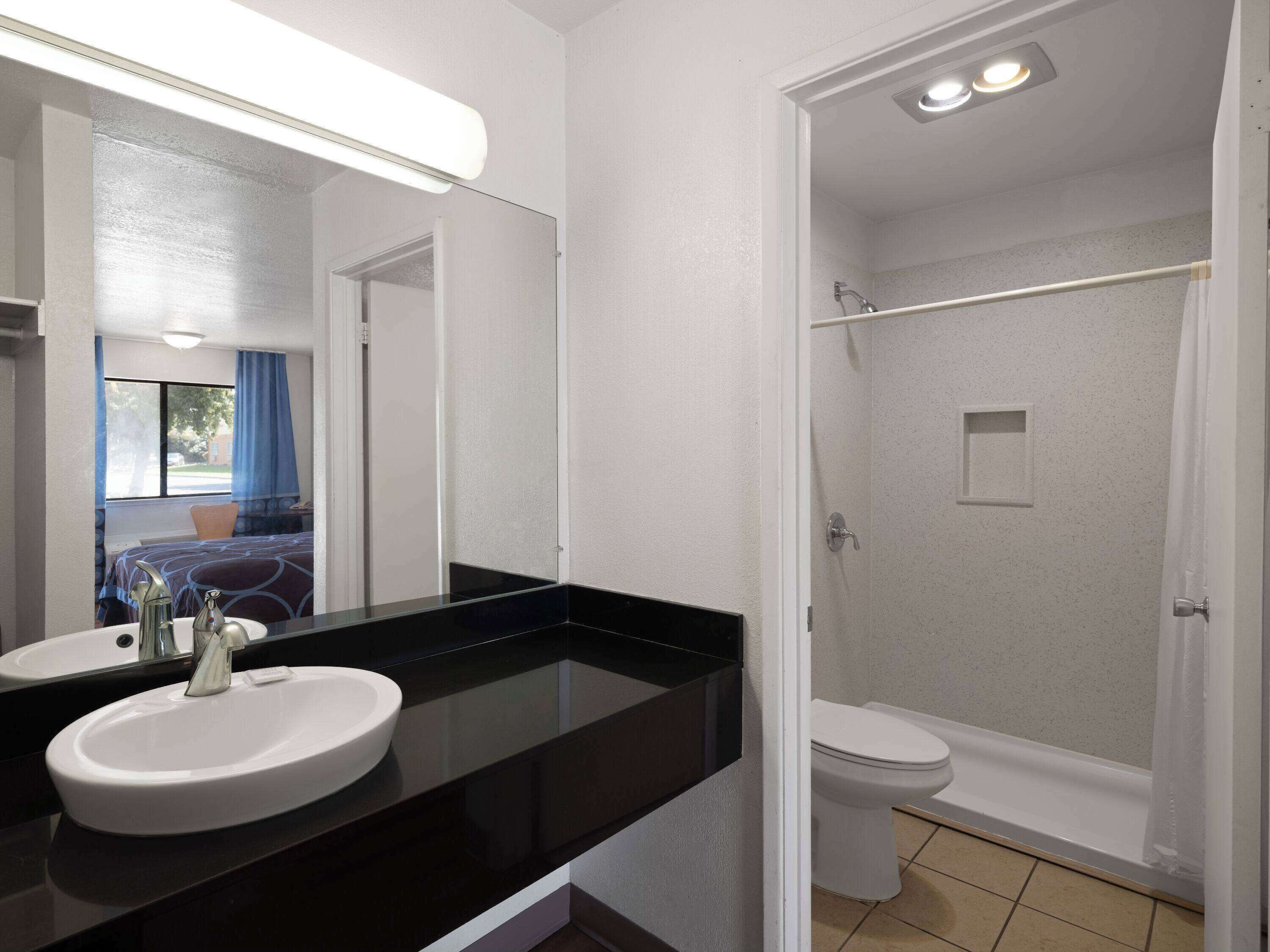 A bathroom with two sinks, a toilet, and a shower.