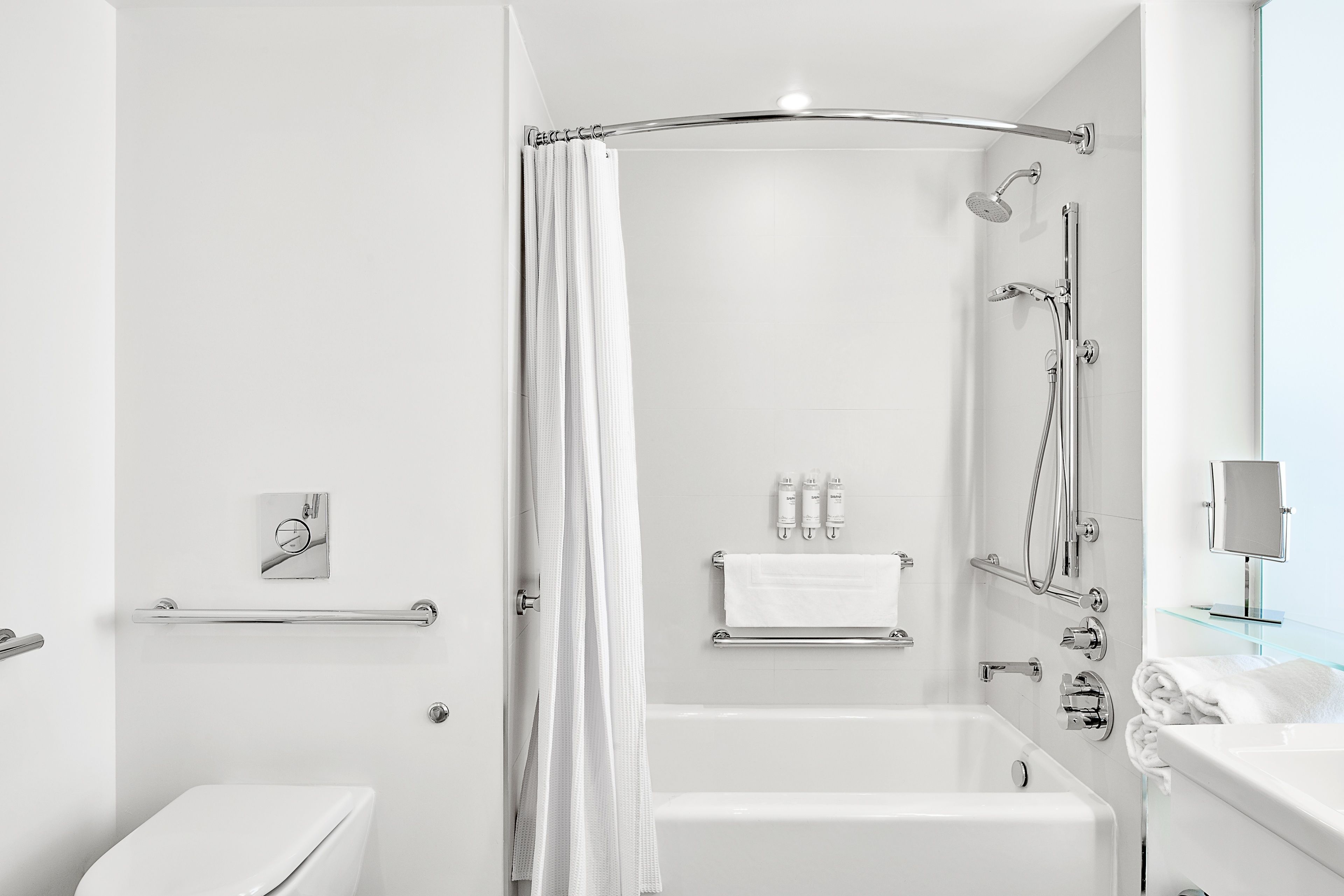 A modern bathroom with a bathtub, shower, and toilet.