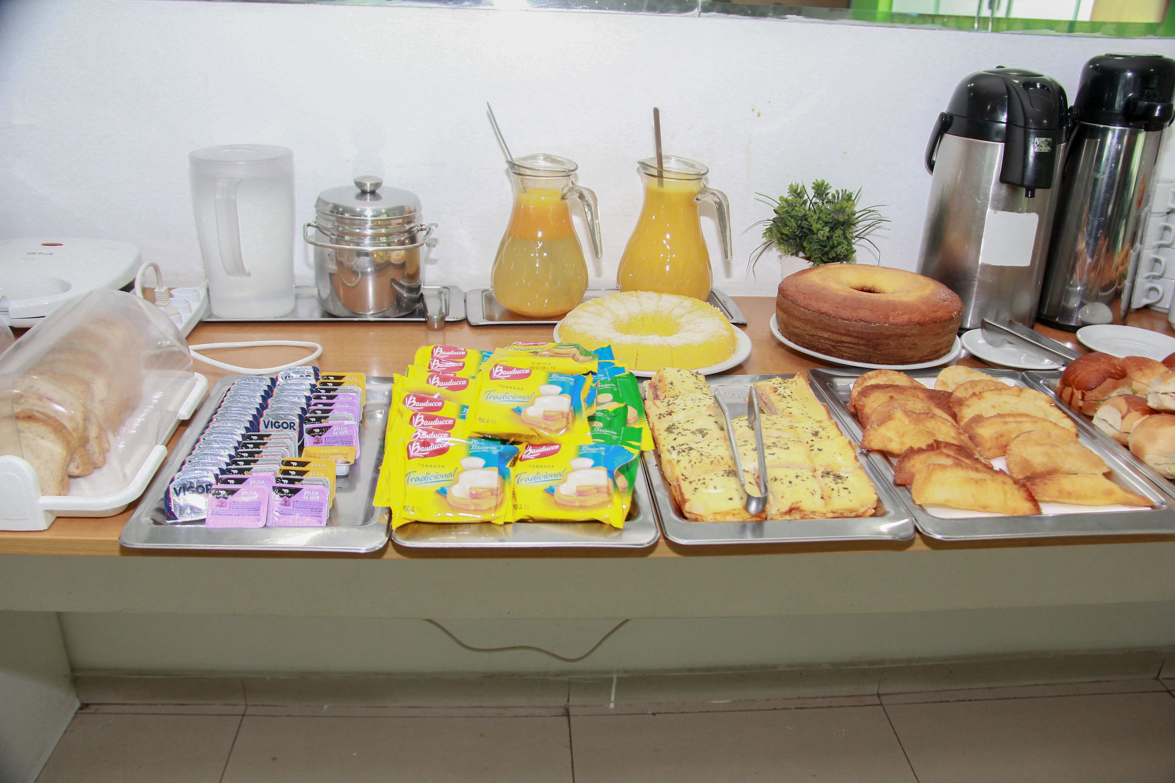 Una mesa de buffet con diversos alimentos, como pasteles, sándwiches y salsas.