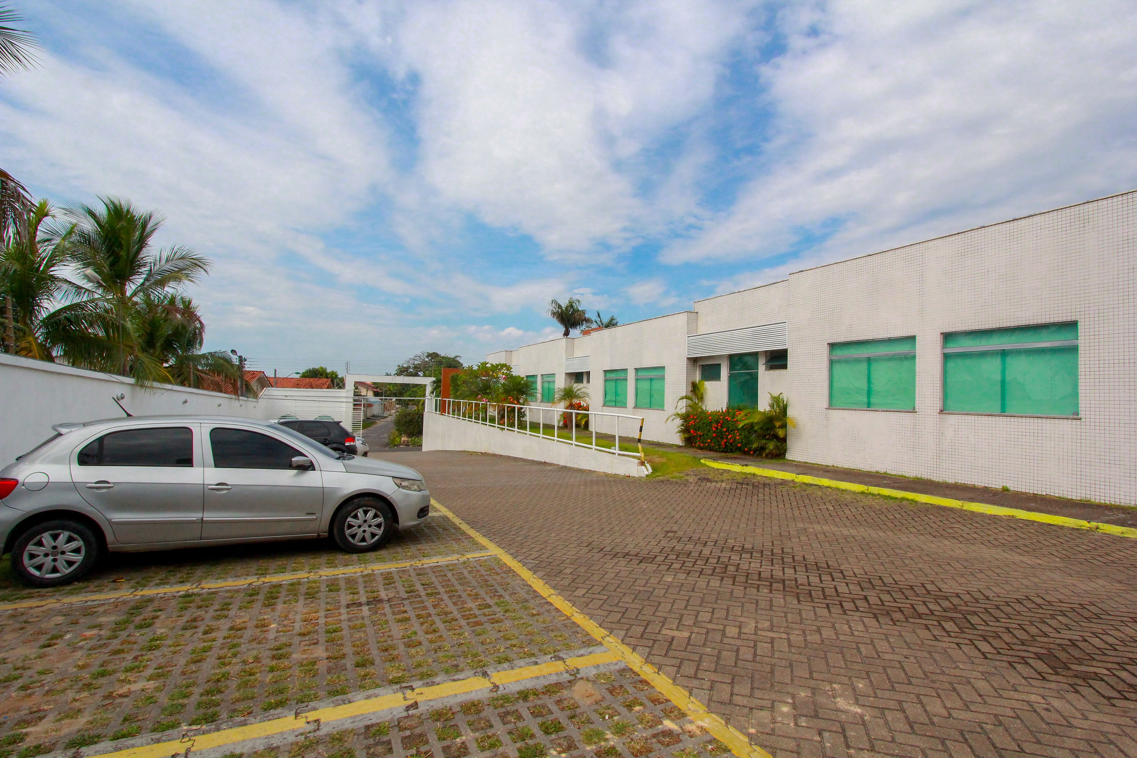 A paved parking area with a car parked on the left.