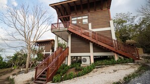 A two-story building with a wooden exterior and a balcony on the upper floor. - Pacaya Lodge & Spa (Catarina)