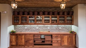 A kitchen with wooden cabinets, a brick backsplash, and hanging baskets. - Pacaya Lodge & Spa (Catarina)