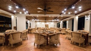A spacious indoor dining area with wicker furniture and a ceiling fan. - Pacaya Lodge & Spa (Catarina)