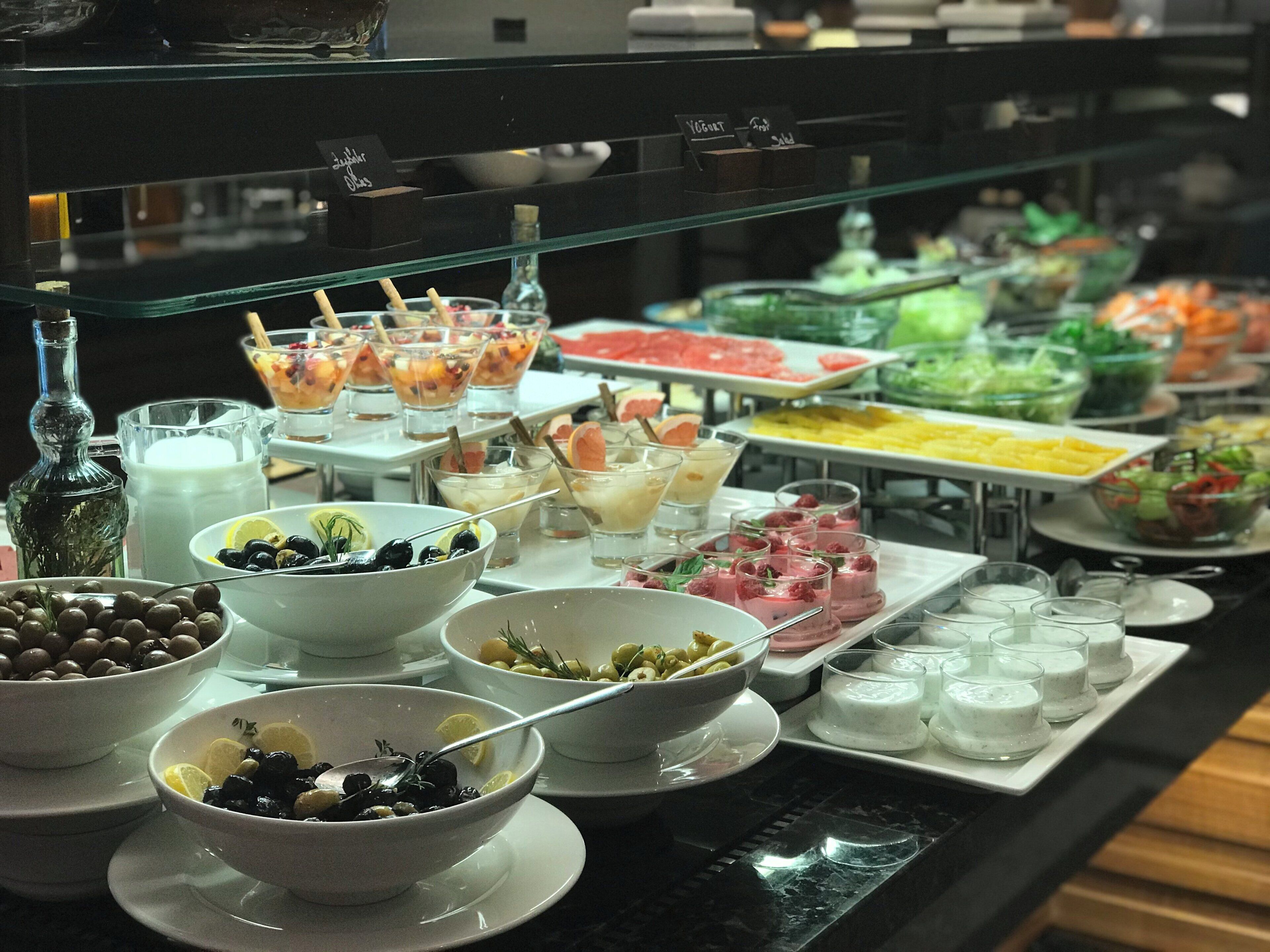 A buffet with various food options including fruits, salads, and desserts.