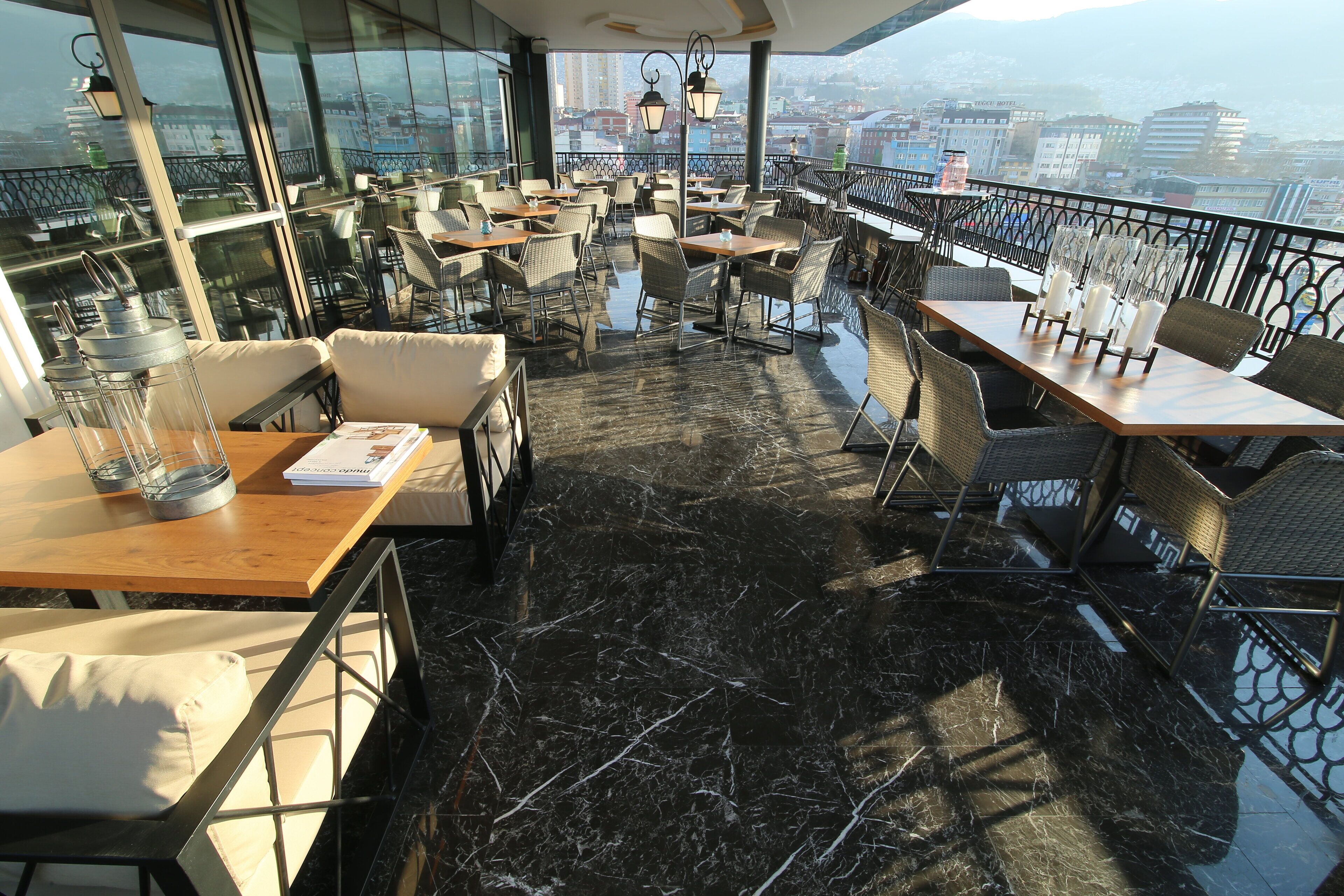 Une terrasse sur le toit avec des sièges extérieurs, une vue sur le paysage urbain et un sol en marbre.
