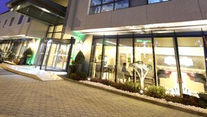 Un hôtel Holiday Inn doté d’une façade moderne, de grandes fenêtres et d’une entrée bien éclairée.