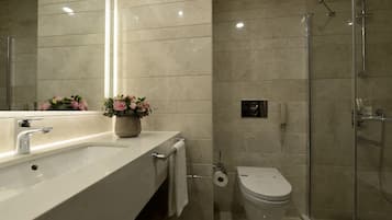 Un baño moderno con un lavamanos grande, un inodoro y una cabina de ducha de vidrio.