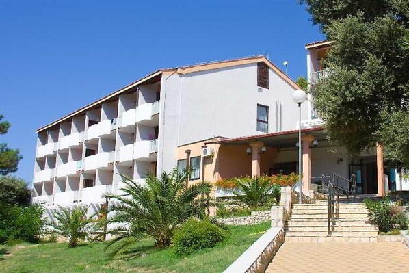 A multi-story hotel with a white facade and a balcony on the upper floors. - Hotel Residence AC SAN Marino (Lopar)