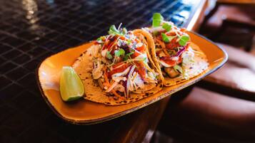 Dos tacos en un plato con una cuña de limón.