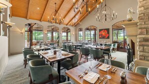 A spacious dining area with high ceilings, chandeliers, and large windows offering views of the outdoors. - Vinarosa Resort & Spa (Santa Rosa)
