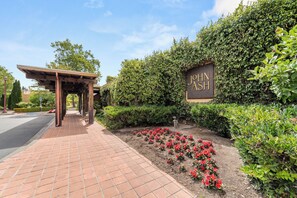 A paved walkway leading to a building with a sign that reads "JOHN JASH".