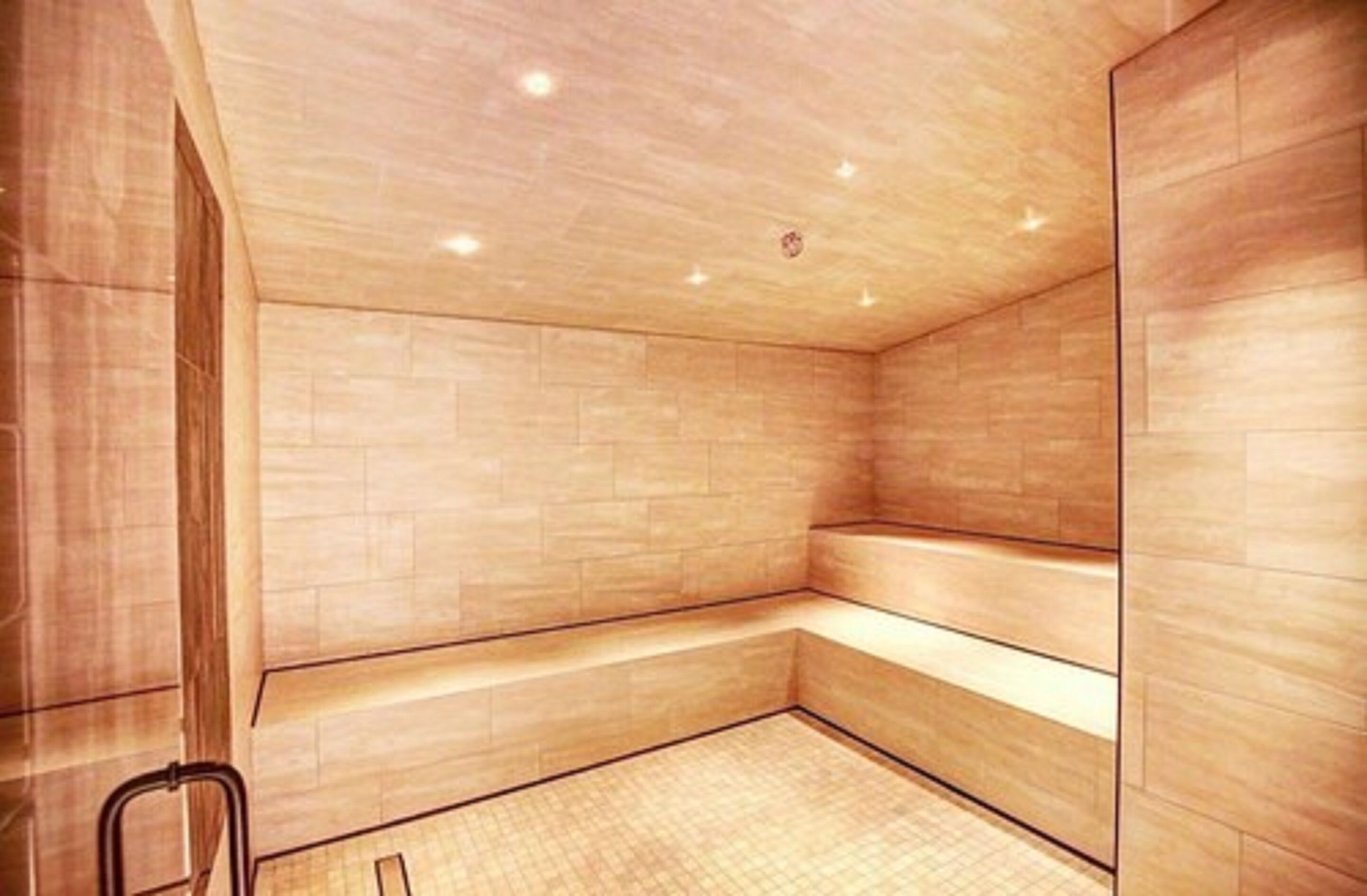 A modern spa room with wooden walls and a bench.