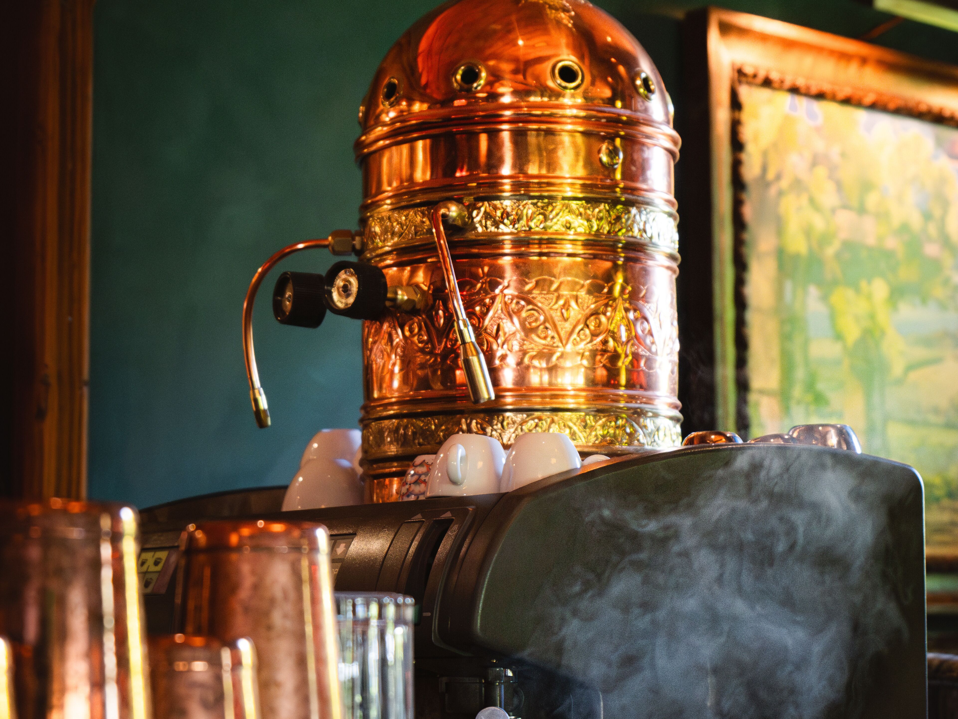 A copper steam engine with intricate engravings, surrounded by various objects.