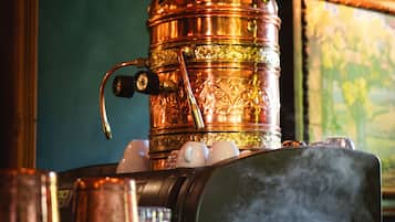 A copper steam engine with intricate engravings, surrounded by various objects.