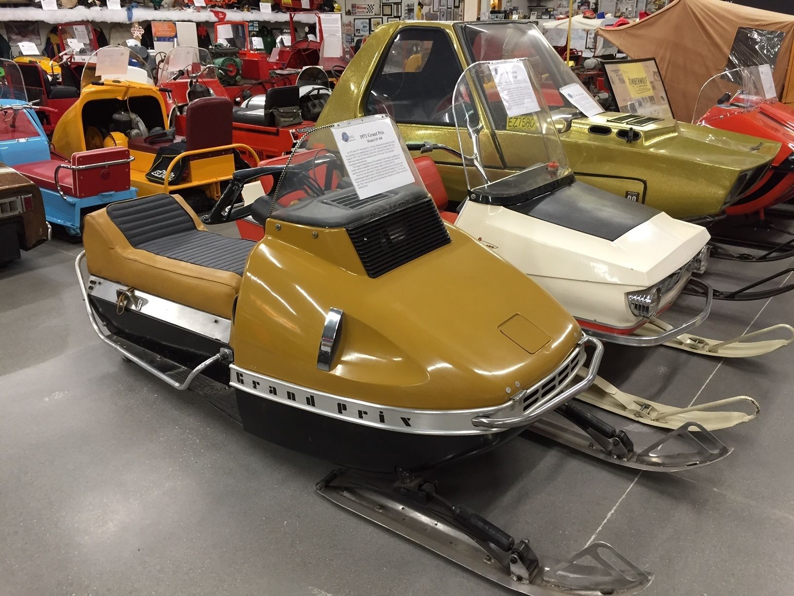 A vintage snowmobile with a sign indicating it is a 1971 Grand Prix model.