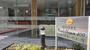 Entrada de hotel con un letrero que indica 'HOTEL Castellana 100' y 'Calle 96 No. 45 A - 19'.