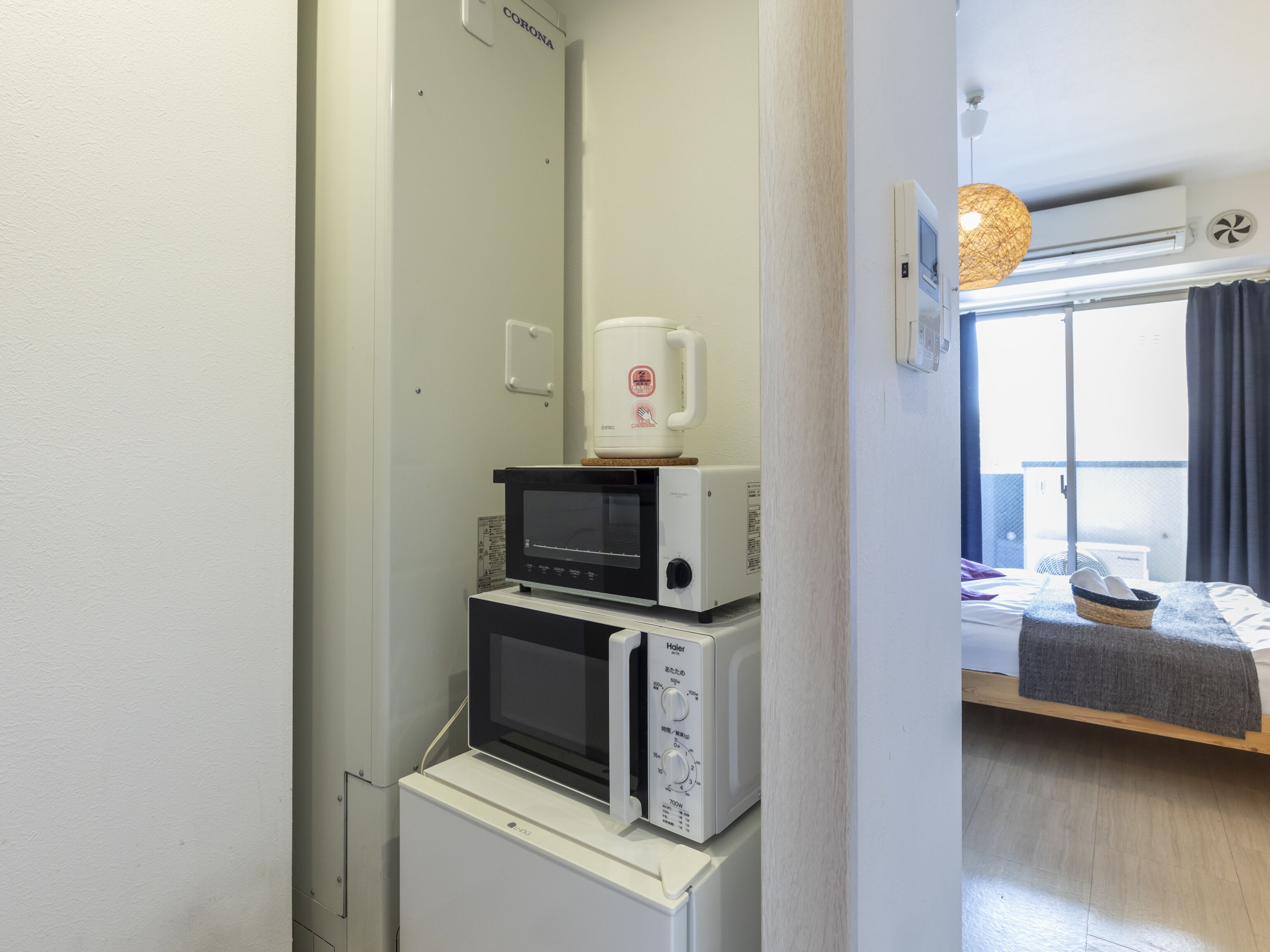 Una kitchenette compacta equipada con microondas, tostadora y cafetera.