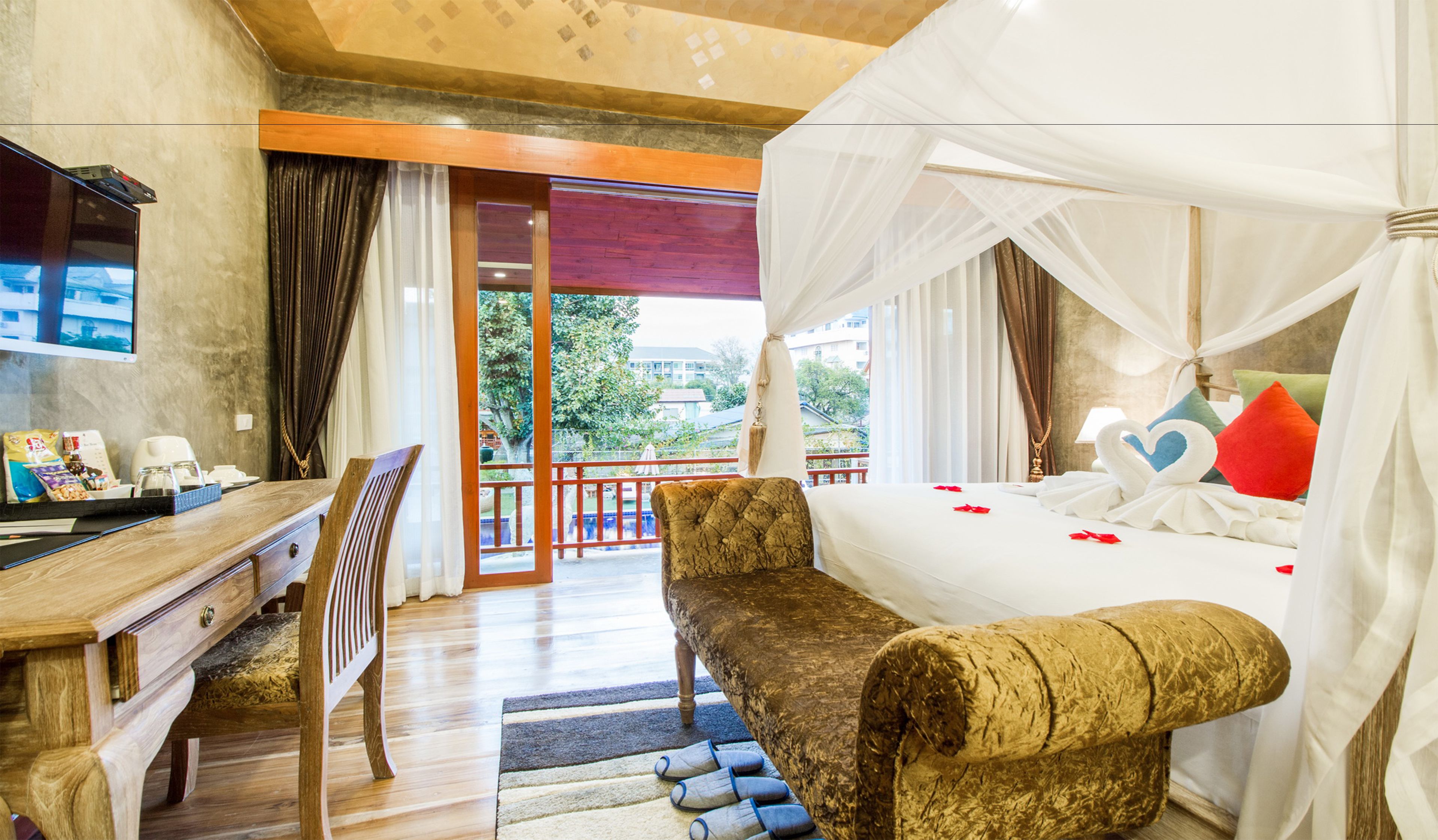 A hotel room with a bed, a desk, a chair, and a view of the outdoors.