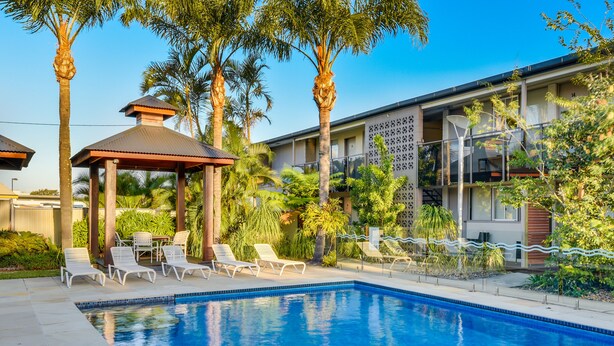 A swimming pool with lounge chairs, a gazebo, and palm trees. - Nightcap at Golden Beach Tavern (Caloundra)