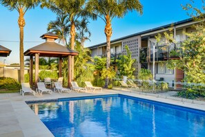 A swimming pool with lounge chairs, a gazebo, and palm trees. - Nightcap at Golden Beach Tavern (Caloundra)