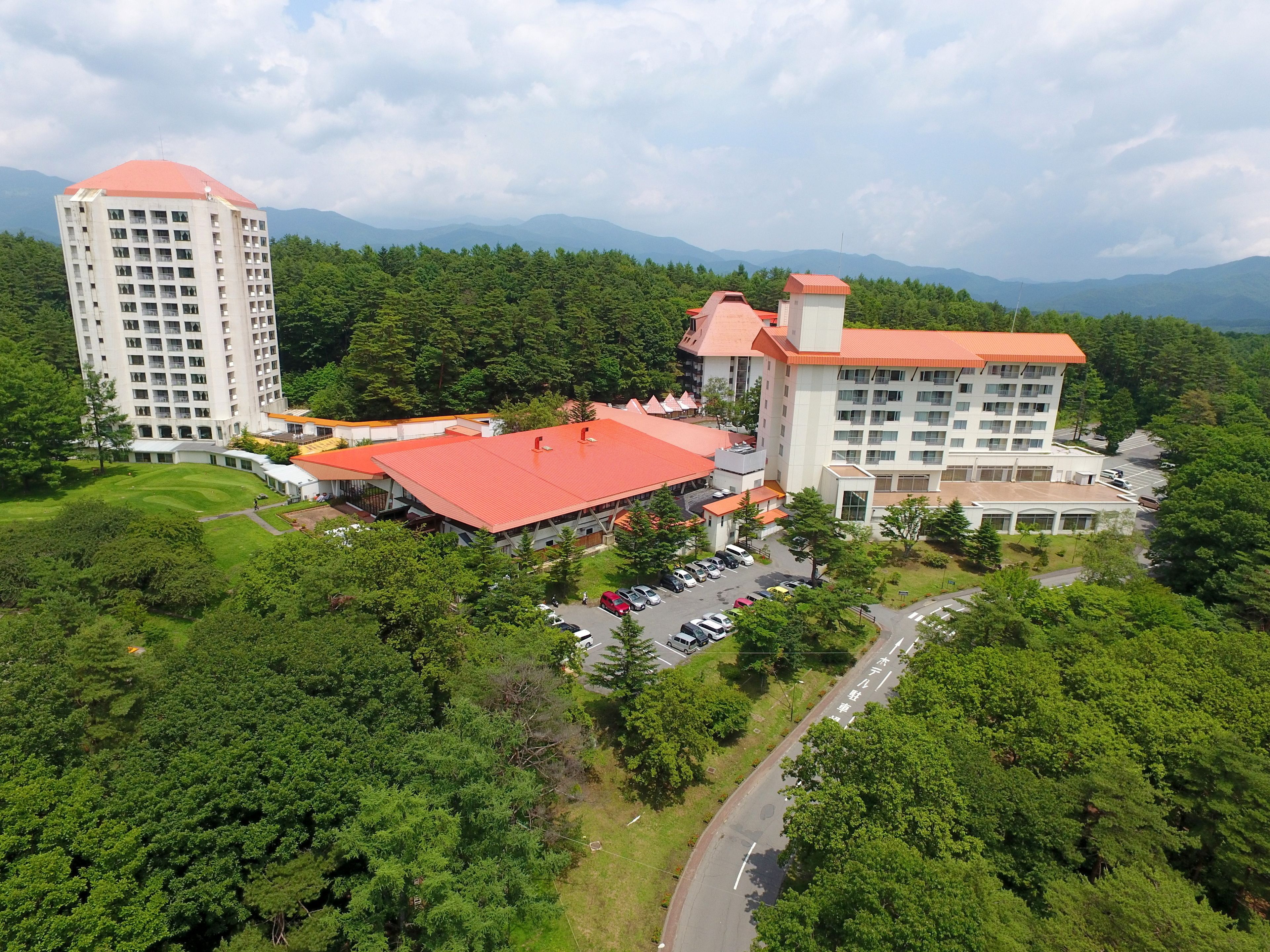 A hotel complex with multiple buildings, including a tall tower and a building with a red roof.