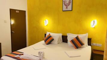 Una habitación de hotel con una cama, dos almohadas, una toalla y una puerta.