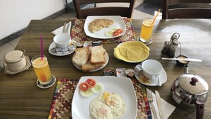A breakfast table with various dishes, including eggs, toast, and a beverage. - Sam's Guest House (Unawatuna)