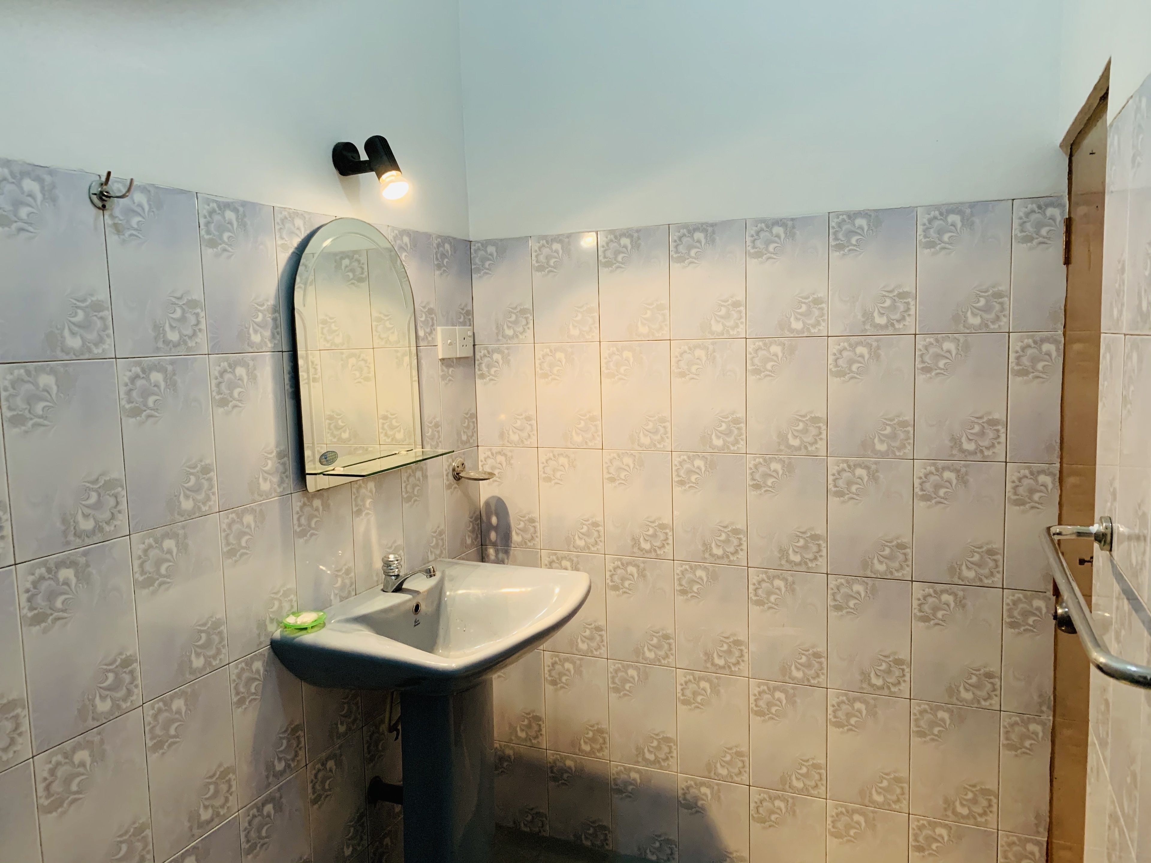 A bathroom with a sink, mirror, and shower.
