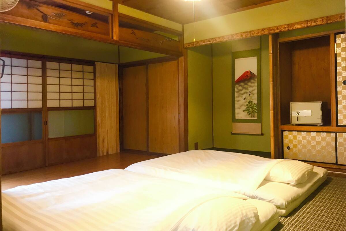 A traditional Japanese-style room with tatami flooring, a low wooden ceiling, and shoji screens.