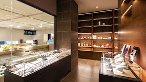 A modern jewelry store with glass display cases, a sofa, and wooden shelving. - Bourou NOGUCHI Noboribetsu - Adult Only (Noboribetsu)